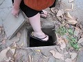 Aislings foot in an original Cu Chi Tunnel entranc