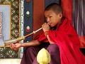 Ein junger Mönch bläst das Horn anlässlich der Puj