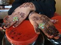 Die mit Henna verzierten Hände einer Verkäuferin.