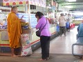 Donatie aan een monnik op de ochtendmarkt