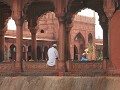 Gelovigen verpozen in de zuilengangen van de moske