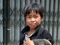 Black Hmong-jongetje draagt z'n biggetje naar huis