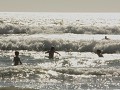  Tussen de surfers de golven in.