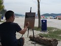 schilderaar aan het werk op Pantai Cenang beach